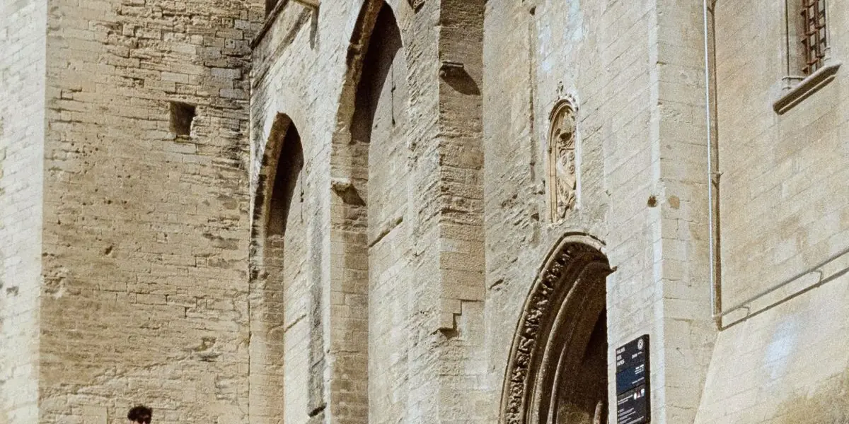 La façade de pierre du Palais des Papes à Avignon et l'escalier qui mène à son entrée.