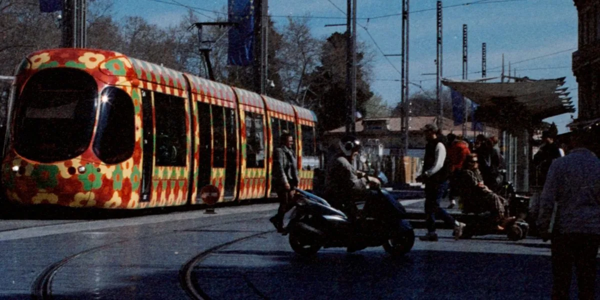 Un tramway aux motifs floraux traverse la place de la Comédie à Montpellier, devant le cinéma Gaumont.